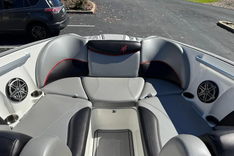 Slide: The Image of 2016 MasterCraft X23 boat interior with gray seating and built-in speakers. - 8