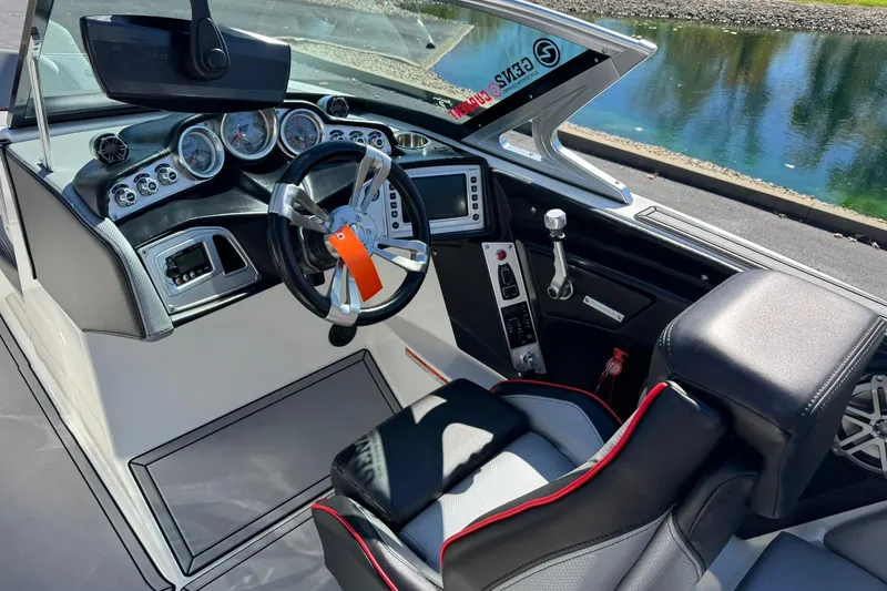 Slide: The Image of 2016 MasterCraft X23 boat interior with steering wheel and dashboard controls. - 9