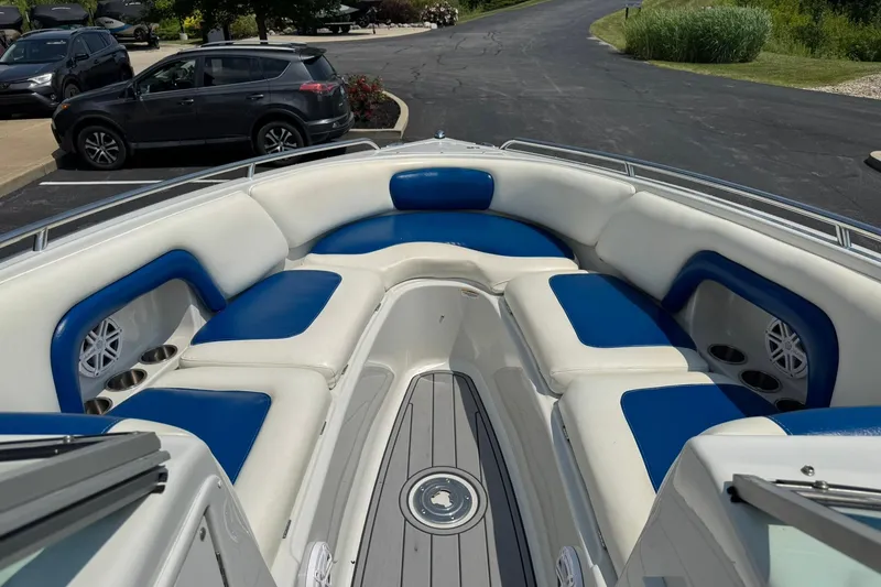 Slide: The Image of 2005 Crownline 270 BR boat with blue and white seating in a parking lot. - 10