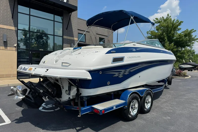 Slide: The Image of 2005 Crownline 270 BR boat on trailer, parked outside a building. - 3