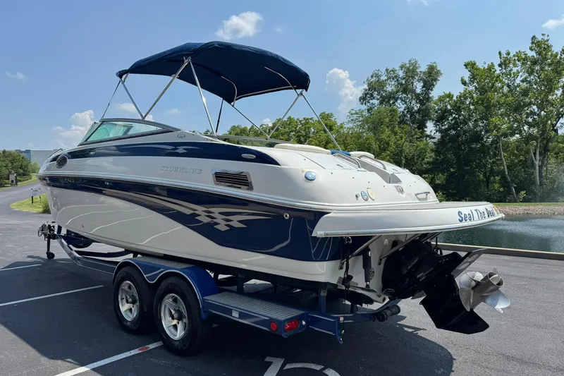 Slide: The Image of 2005 Crownline 270 BR boat on trailer, parked near a scenic lake. - 6