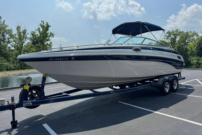 Slide: The Image of 2005 Crownline 270 BR boat on trailer, parked outdoors under a clear sky. - 8