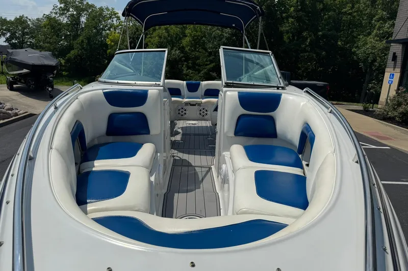 Slide: The Image of 2005 Crownline 270 BR boat with blue and white seating, docked outdoors. - 9
