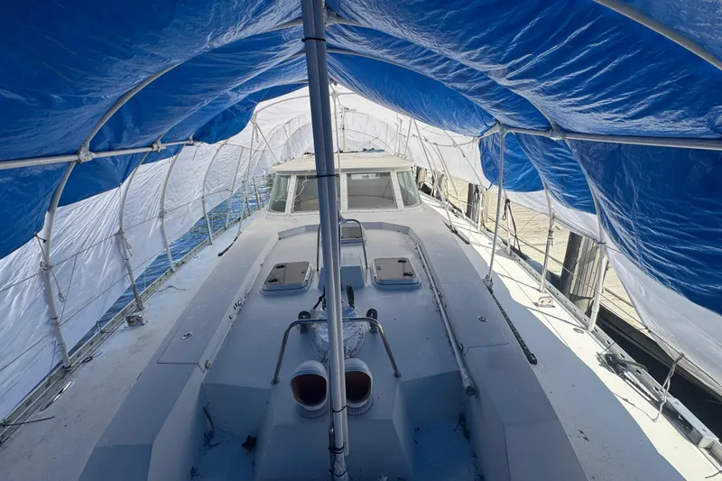 Slide: The Image of 1996 Blue Water 60 Ketch sailboat under blue and white tarp cover at dock. - 4