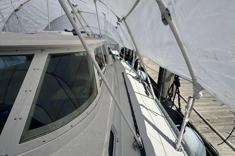 Slide: The Image of 1996 Blue Water 60 Ketch sailboat under protective cover at dockside. - 5