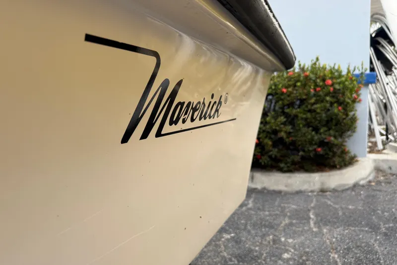 Slide: The Image of 2003 Maverick 18 Master Angler boat with logo, parked near greenery. - 8