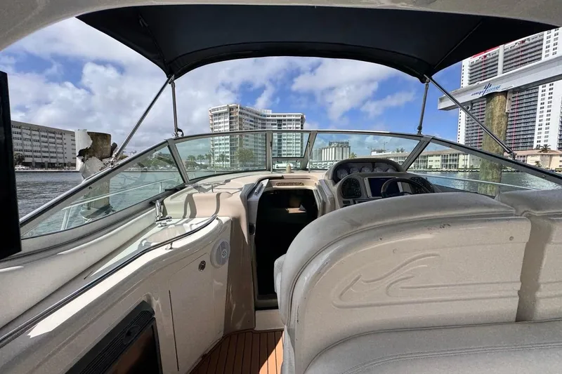 Slide: The Image of 2005 Sea Ray 300 Sundancer boat interior with cityscape view, under a clear blue sky. - 12