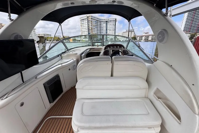 Slide: The Image of 2005 Sea Ray 300 Sundancer boat interior with seating, dashboard, and waterfront view. - 15