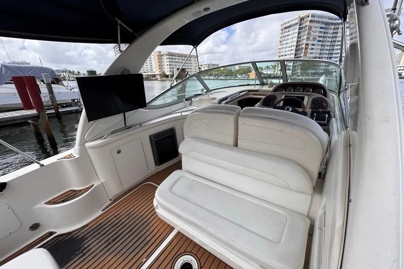 Slide: The Image of 2005 Sea Ray 300 Sundancer interior with helm, seating, and waterfront view. - 16