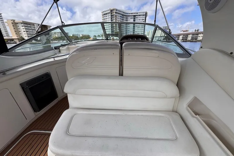Slide: The Image of 2005 Sea Ray 300 Sundancer interior with white seating and waterfront view. - 17
