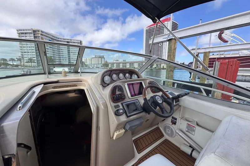 Slide: The Image of 2005 Sea Ray 300 Sundancer helm with cityscape view, featuring modern controls and comfortable seating. - 20