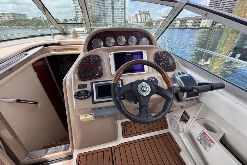 Slide: The Image of Cockpit of 2005 Sea Ray 300 Sundancer with steering wheel and navigation controls. - 21