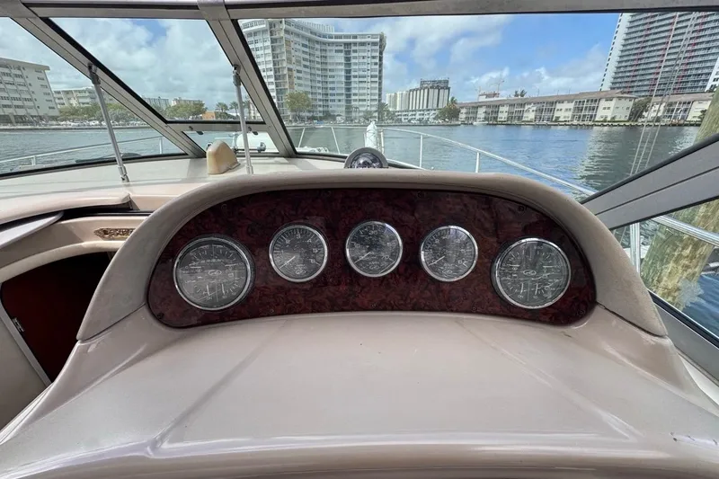 Slide: The Image of Dashboard view of a 2005 Sea Ray 300 Sundancer boat with cityscape background. - 24