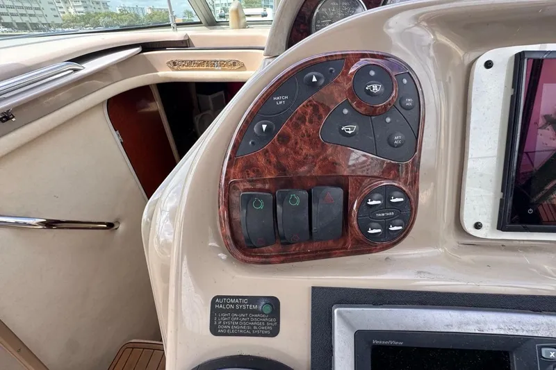 Slide: The Image of Control panel of a 2005 Sea Ray 300 Sundancer boat with various switches and buttons. - 25