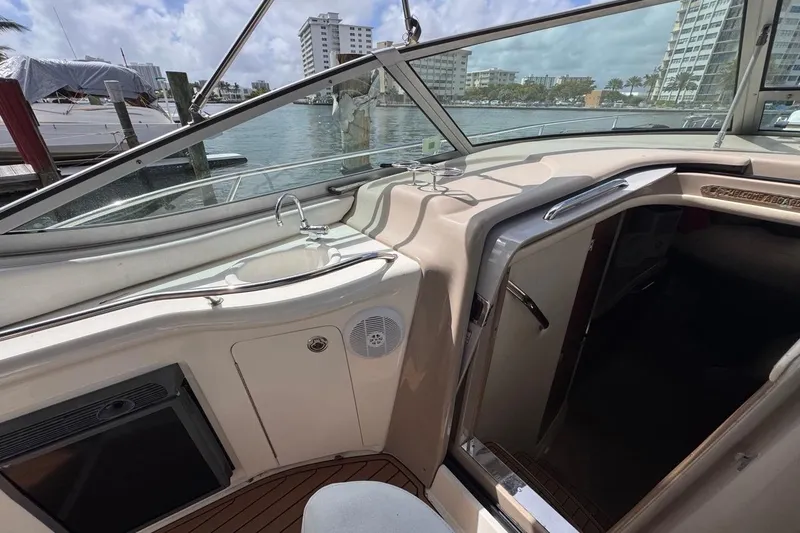 Slide: The Image of 2005 Sea Ray 300 Sundancer cockpit with sink, overlooking marina and cityscape. - 26