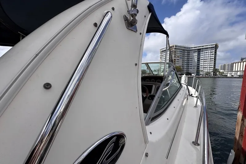 Slide: The Image of 2005 Sea Ray 300 Sundancer docked near waterfront buildings under a cloudy sky. - 31