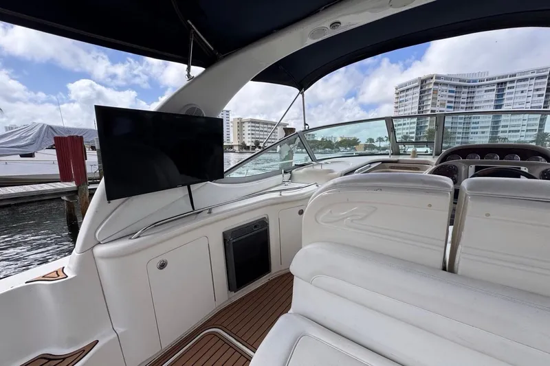 Slide: The Image of 2005 Sea Ray 300 Sundancer yacht interior with TV, docked near waterfront buildings. - 32