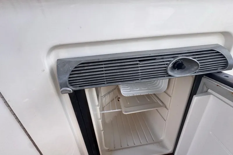 Slide: The Image of Open refrigerator on 2005 Sea Ray 300 Sundancer boat, showing interior shelves. - 33
