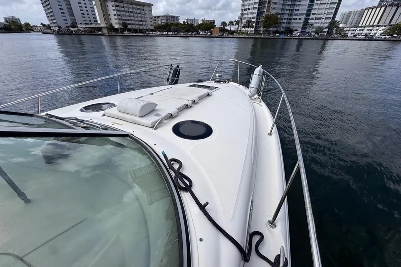 Slide: The Image of 2005 Sea Ray 300 Sundancer yacht on calm water near urban buildings. - 44