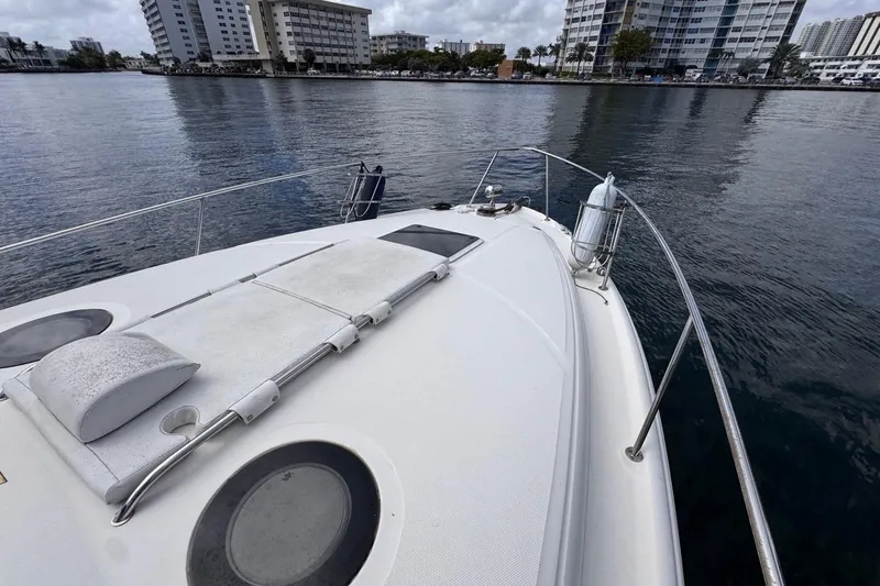 Slide: The Image of 2005 Sea Ray 300 Sundancer yacht on calm water near urban skyline. - 45