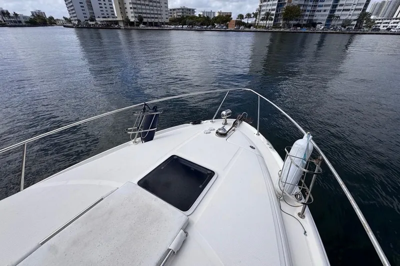 Slide: The Image of Bow view of 2005 Sea Ray 300 Sundancer yacht on calm waters near urban skyline. - 46