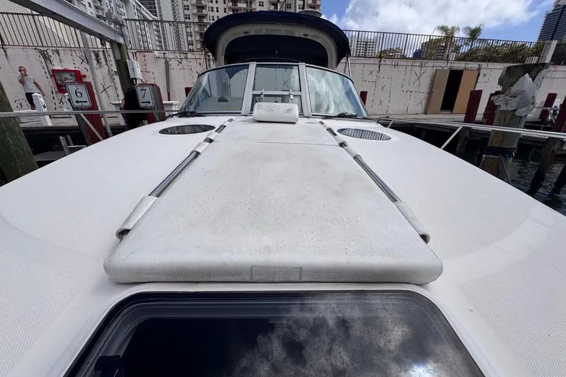 Slide: The Image of 2005 Sea Ray 300 Sundancer yacht docked, showcasing spacious deck and sleek design. - 48