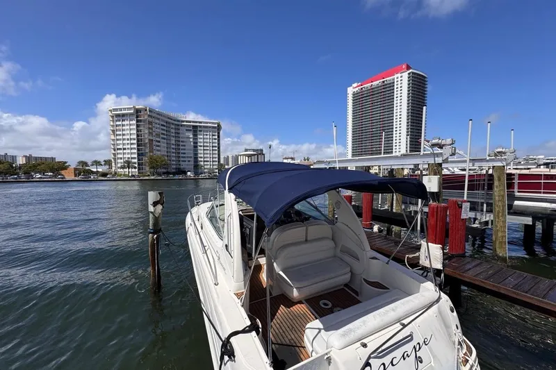 Slide: The Image of 2005 Sea Ray 300 Sundancer docked at marina with cityscape background. - 5