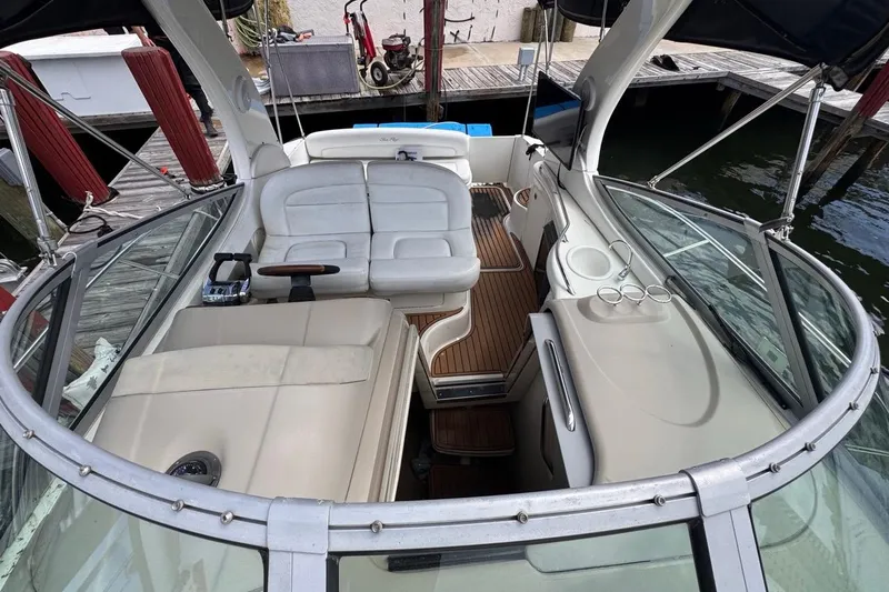 Slide: The Image of 2005 Sea Ray 300 Sundancer boat interior with seating and wood flooring at a dock. - 50