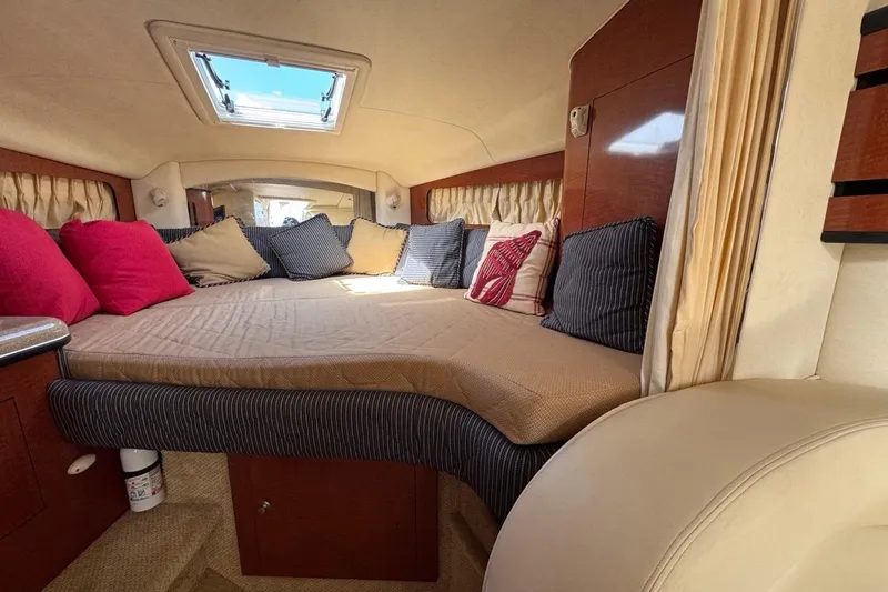 Slide: The Image of 2005 Sea Ray 300 Sundancer cabin interior with cozy bed and colorful pillows. - 51