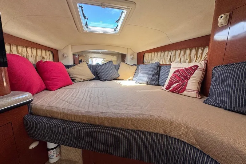 Slide: The Image of Interior cabin of 2005 Sea Ray 300 Sundancer with cozy bedding and decorative pillows. - 52