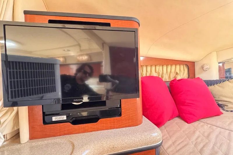Slide: The Image of Interior of 2005 Sea Ray 300 Sundancer with TV and red cushions. - 53