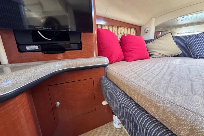 Slide: The Image of Interior of 2005 Sea Ray 300 Sundancer with TV, bed, and colorful cushions. - 55