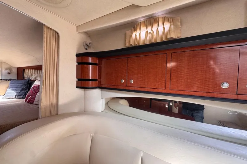 Slide: The Image of Interior of 2005 Sea Ray 300 Sundancer with wood cabinets and cozy seating area. - 56