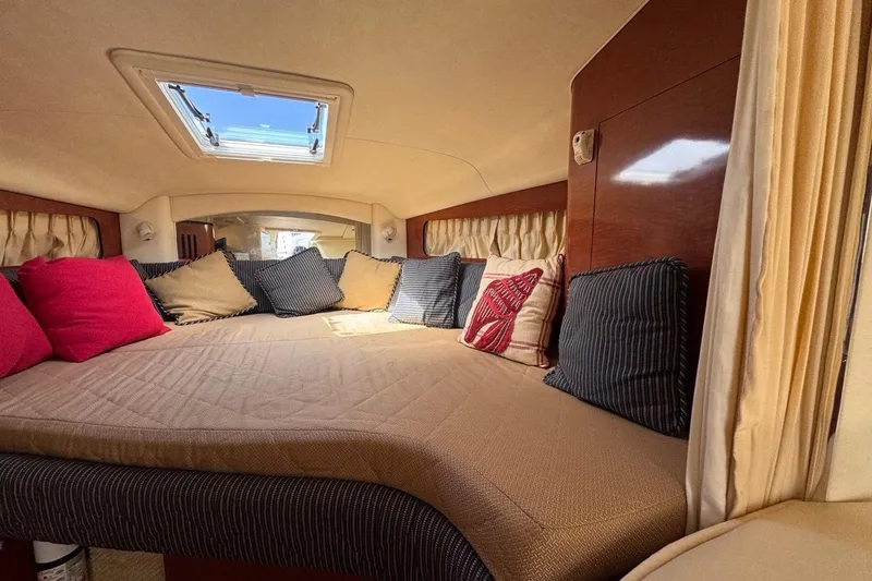 Slide: The Image of Interior of 2005 Sea Ray 300 Sundancer with cozy bed and colorful cushions. - 58