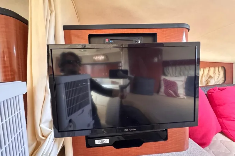 Slide: The Image of 2005 Sea Ray 300 Sundancer interior with Insignia TV and cozy cabin decor. - 61