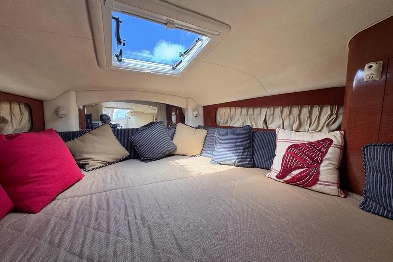 Slide: The Image of Cozy cabin interior of 2005 Sea Ray 300 Sundancer with colorful cushions and skylight. - 62
