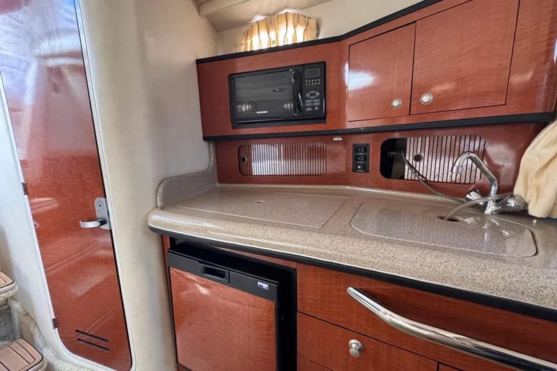 Slide: The Image of Interior of 2005 Sea Ray 300 Sundancer boat kitchen with microwave and sink. - 68