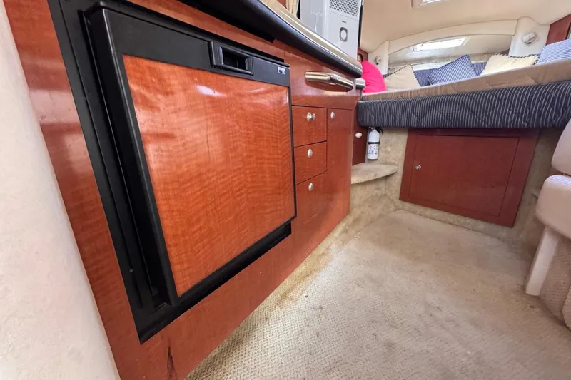 Slide: The Image of Interior of 2005 Sea Ray 300 Sundancer with wood cabinetry and cozy sleeping area. - 69