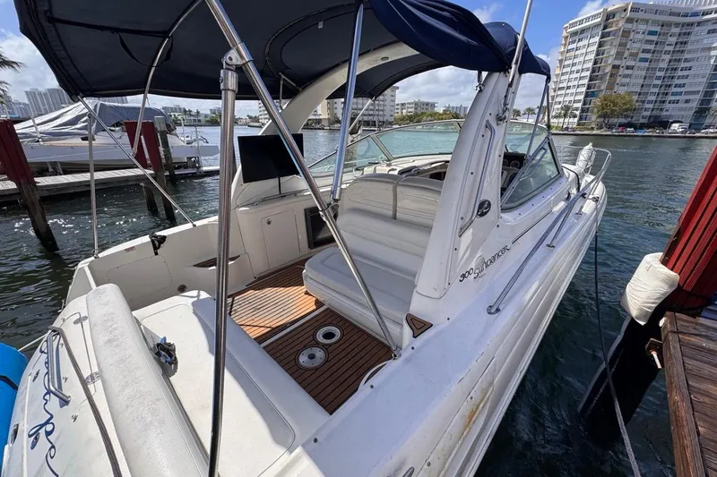 Slide: The Image of 2005 Sea Ray 300 Sundancer boat docked, featuring spacious deck and canopy. - 7