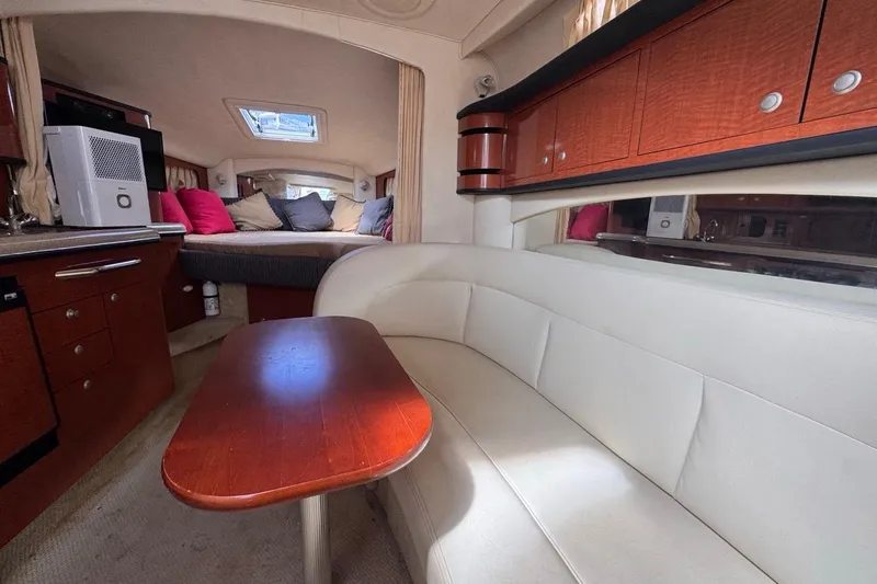 Slide: The Image of Interior of 2005 Sea Ray 300 Sundancer with cozy seating and wooden cabinetry. - 71