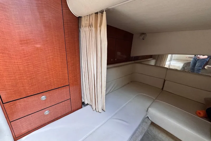 Slide: The Image of Interior of 2005 Sea Ray 300 Sundancer with beige seating and wooden cabinetry. - 74
