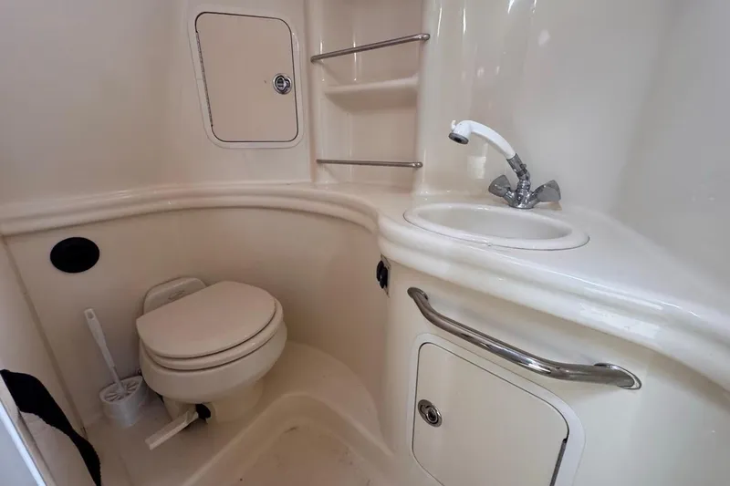 Slide: The Image of 2005 Sea Ray 300 Sundancer bathroom with toilet, sink, and storage compartments. - 75
