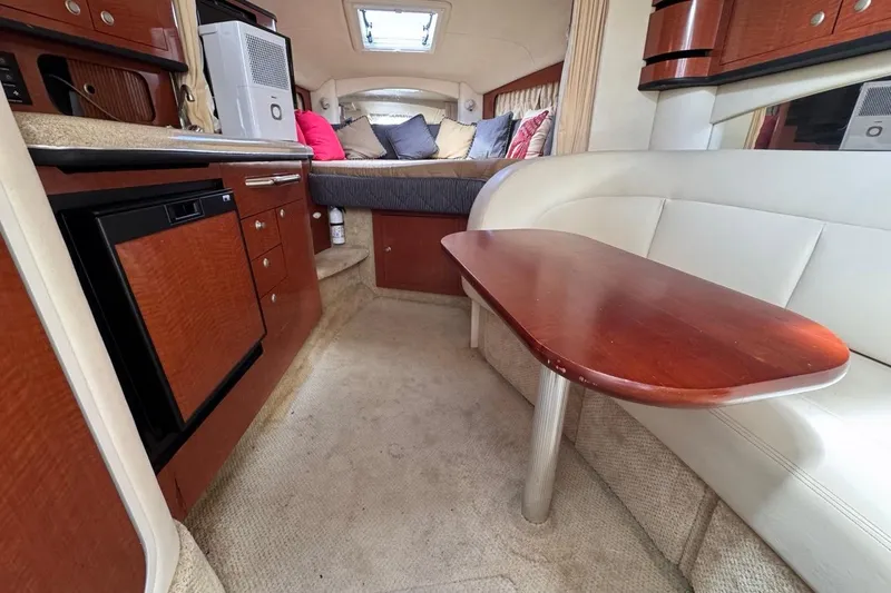 Slide: The Image of Interior of 2005 Sea Ray 300 Sundancer with kitchenette, seating, and bed. - 82