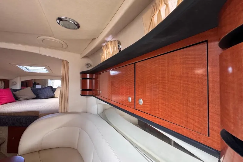 Slide: The Image of Interior of 2005 Sea Ray 300 Sundancer with wood cabinets and cozy seating area. - 86