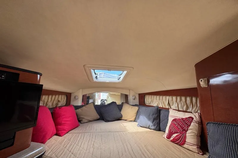 Slide: The Image of Interior of 2005 Sea Ray 300 Sundancer with cozy bedding and decorative pillows. - 87
