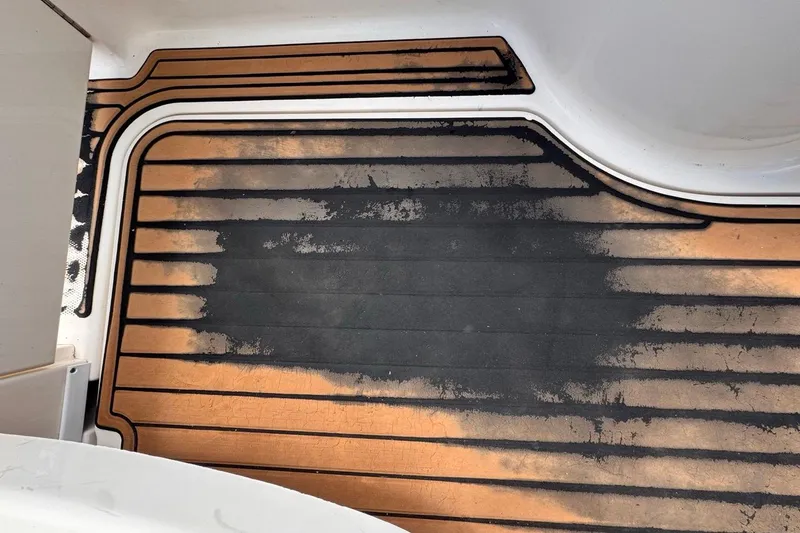Slide: The Image of Worn deck of 2005 Sea Ray 300 Sundancer boat, showing weathered surface and faded colors. - 91