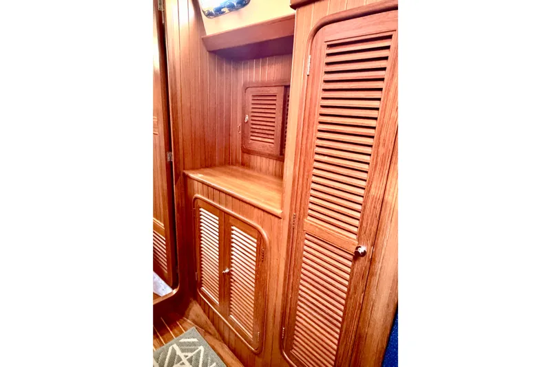 Slide: The Image of Wooden interior cabinetry of 2001 Tayana Vancouver 42 sailboat, featuring louvered doors. - 15