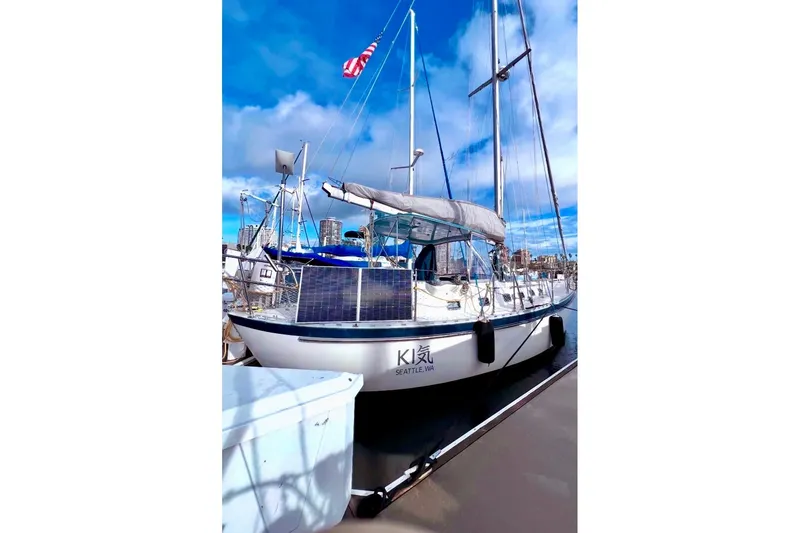 Slide: The Image of 2001 Tayana Vancouver 42 sailboat docked, featuring solar panels and American flag. - 2