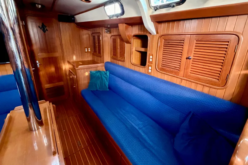 Slide: The Image of Interior of 2001 Tayana Vancouver 42 yacht with blue seating and wooden cabinetry. - 7