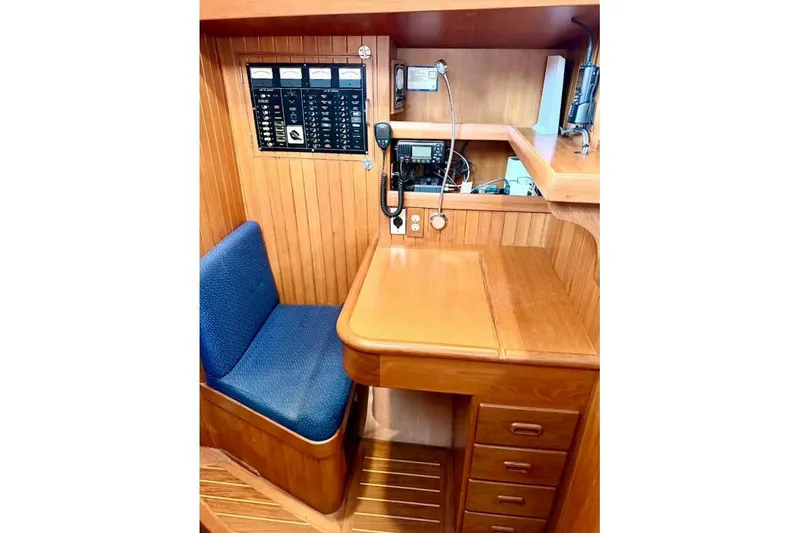 Slide: The Image of Navigation station in 2001 Tayana Vancouver 42 yacht with wooden desk and blue seat. - 8